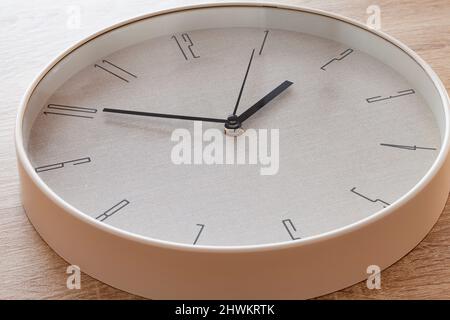 Gros plan d'une grande main d'horloge ronde marquant dix à deux heures. Banque D'Images