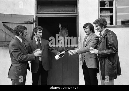 Il s'agit d'un run in All Lancashire pour les quatre championnats de la ligue de football et les quatre capitaines des meilleures équipes se sont réunis pour un match d'échecs amical. Les joueurs impliqués sont Tommy Smith (Liverpool), Martin Dobson (Burnley), Warwick Rimmer (Bolton) et John McPhee (Southport). Après le match, les quatre footballeurs ont ouvert une bouteille de champagne pour porter un toast à la santé d'un autre champion du Lancashire, Red Rum, vainqueur du Grand National, photographié dans son écurie de Southport. 6th avril 1973. Banque D'Images