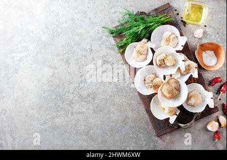 Coquilles Saint-Jacques crues sur plateau en bois de fruits de mer méditerranéens. Mollusques frais. Aequipecten opercularis. Jacobaeus Pecten Banque D'Images