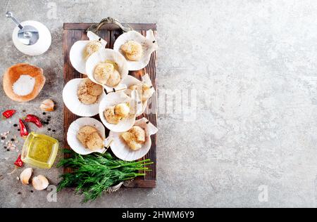 Coquilles Saint-Jacques crues sur plateau en bois de fruits de mer méditerranéens. Mollusques frais. Aequipecten opercularis. Jacobaeus Pecten Banque D'Images
