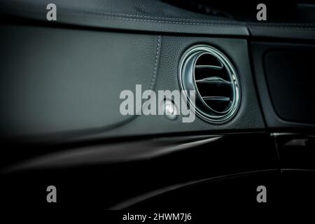 Ventilation côté passager dans une voiture moderne. Orifice rond visible pour l'aération de la vitre latérale dans un tableau de bord en cuir dans une voiture de luxe. Banque D'Images
