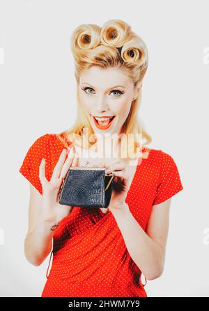 Concept d'économies. Rétro pinup femme économie d'argent dans la caisse. Épinglez une fille dans un style vintage femme au foyer. Banque D'Images