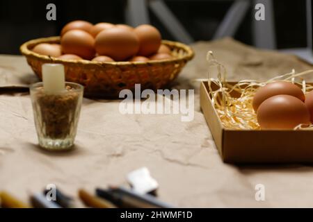 Collection d'œufs sur fond noir. Boîte de Pâques avec œufs bruns sur fond écologique. Œufs de poulet sur une table d'artisanat avec du foin et de la paille. Gros plan v Banque D'Images