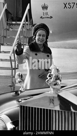 La reine Elizabeth II se fait une vague vers les spectateurs, alors qu'elle se rend à sa voiture depuis l'avion, à l'aéroport de Glamorgan, au Rhoose. 9th mars 1973. Banque D'Images