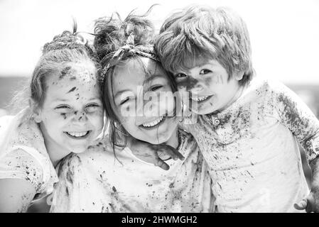 Portrait des enfants heureux dans des holos de poudre colorés. Le visage des enfants est peint dans les couleurs du festival Holi. Holi paint Party. Banque D'Images