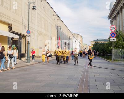 Moscou. Russie. 9 mai 2021. Des hommes sous la forme de soldats soviétiques marchent le long de la rue de la ville avec un drapeau rouge. Banque D'Images