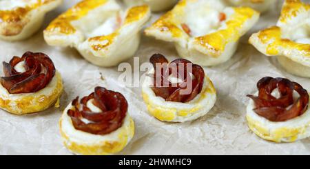 pâtisseries maison fraîches. mélange de hors-d'œuvre feuilletés. gâteau au pepperoni en forme de rose. pâtisserie avec salami. Banque D'Images