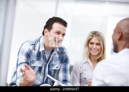 Il est confiant dans les capacités des membres de son équipe. Un groupe de professionnels ayant une discussion de travail. Banque D'Images