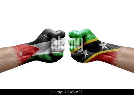 Deux mains poinçonner l'une à l'autre sur fond blanc. Drapeaux de pays peints poings, concept de crise de conflit entre la jordanie et saint-kitts-et-nevis Banque D'Images