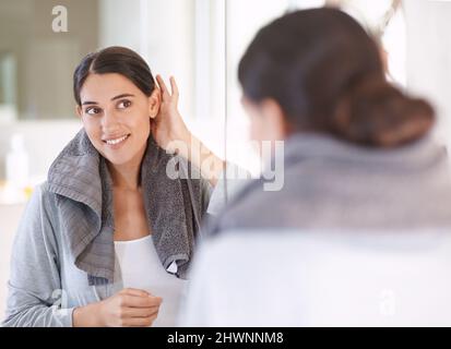 Finissant sa routine du matin. Une jeune femme sèche ses cheveux après une douche. Banque D'Images