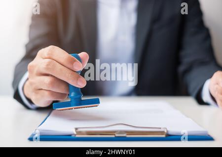 Cachet de l'homme d'affaires au moment de la signature du contrat. Contrat d'affaires, approbation, partenariat, contrat et concepts d'assurance qualité Banque D'Images