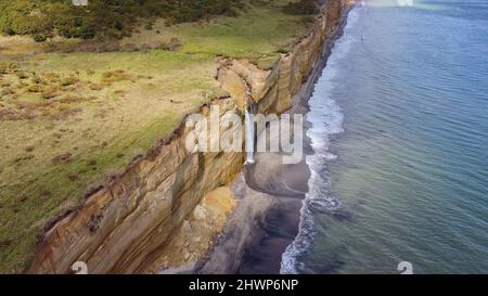 Cascade sur la falaise de Golovinsky sur l'île de Kunashir, îles Kuril, Russie.Photographie aérienne. Banque D'Images