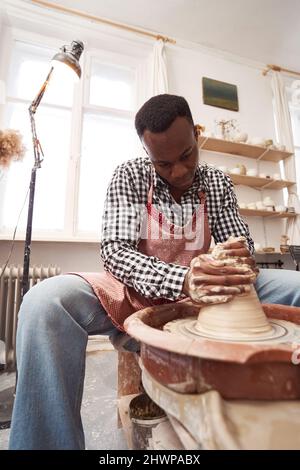 Ceramist masculin concentré travaillant dans son atelier Banque D'Images