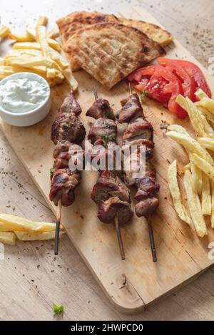 Plat de Souvlaki, viande grecque. Brochettes grillées et pain pita sur une table en bois, vue rapprochée au-dessus, Banque D'Images