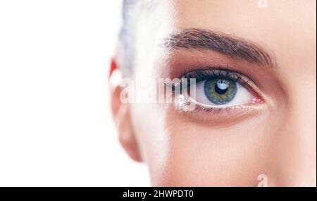 La beauté est dans L'ŒIL du porte-bec. Studio portrait d'une belle jeune femme isolée sur blanc. Banque D'Images