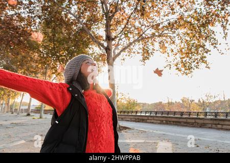 Jeune femme gaie avec les bras tendus debout sur le sentier Banque D'Images