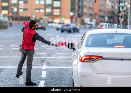 Artiste tenant un chapeau en taxi dans la rue en ville Banque D'Images