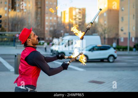 Un artiste de rue jonglant avec des torches enflammées en ville Banque D'Images