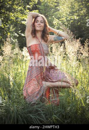 Femme debout sur une jambe au milieu des plantes en forêt Banque D'Images