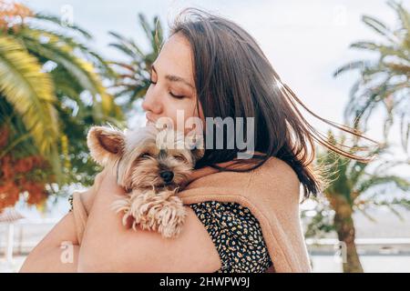 Femme embrassant le Yorkshire Terrier par beau temps Banque D'Images