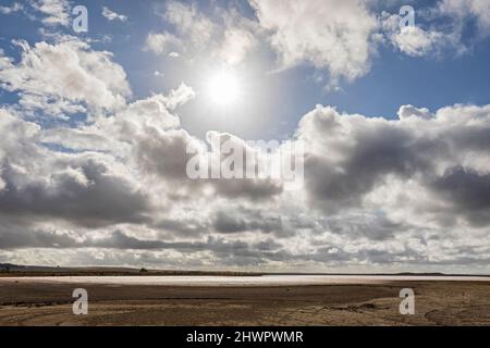 Australie, Australie du Sud, Meningie, soleil qui brille à travers les nuages au-dessus de la rive du lac Pink Banque D'Images