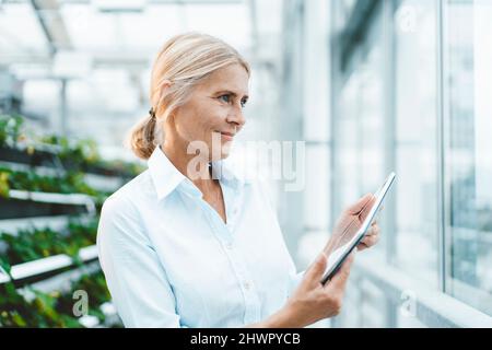 Scientifique avec tablette PC dans le jardin urbain Banque D'Images