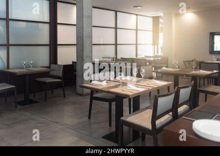 Chaises et tables avec verres disposés dans un restaurant vide Banque D'Images