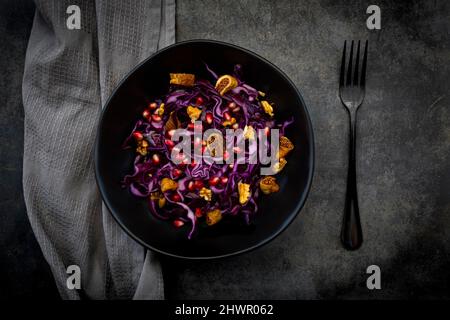 Studio shot de bol de salade végétalienne avec chou rouge, graines de grenade, figues séchées et noix Banque D'Images