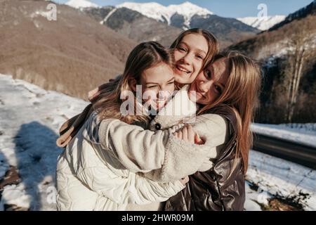 Des amis enjoués par les adolescents se embrassant les uns les autres par temps ensoleillé Banque D'Images