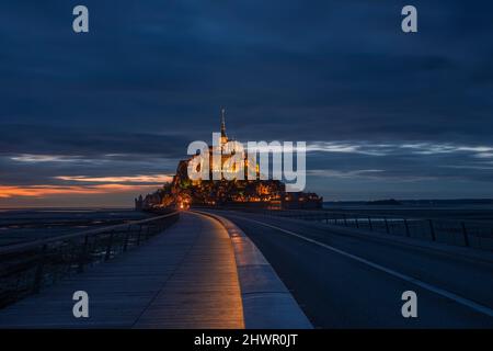 France, Normandie, ciel nuageux sur pont reliant l'île du Mont-Saint-Michel au crépuscule Banque D'Images