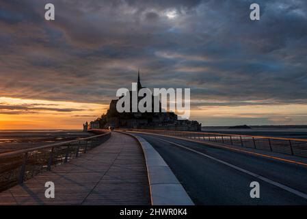 France, Normandie, ciel nuageux sur pont reliant l'île du Mont-Saint-Michel au crépuscule Banque D'Images