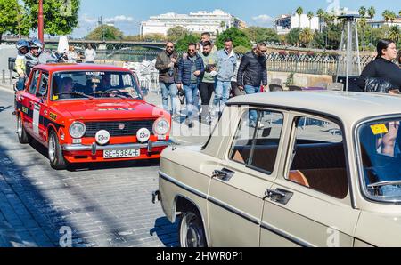 Groupe d'hommes regardant une voiture classique. Siège rouge 124 avec autocollants. Banque D'Images