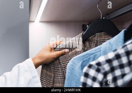 Une jeune femme prend ses vêtements dans le placard Banque D'Images