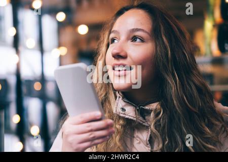 Jeune femme envoyant la messagerie vocale via un smartphone Banque D'Images