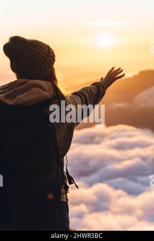 Femme en train de faire la gestuelle en regardant le coucher du soleil à la réserve naturelle du Caucase à Sotchi, Russie Banque D'Images