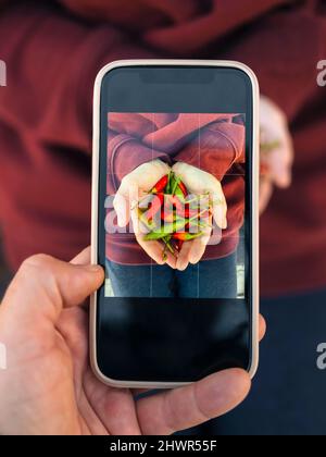 Homme photographiant une femme tenant des enfants avec un smartphone Banque D'Images