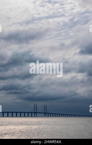 Ciel nuageux au-dessus du détroit de son avec silhouette du pont d'Oresund en arrière-plan Banque D'Images