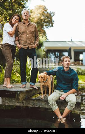 Famille avec chien sur la jetée au bord du lac à l'arrière-cour Banque D'Images