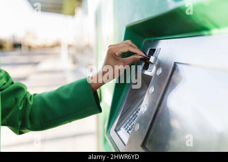 Main d'une femme d'affaires en insérant une carte à puce dans la machine à billets Banque D'Images