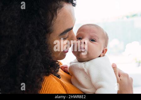 Une mère affectueuse transportant un bébé garçon Banque D'Images