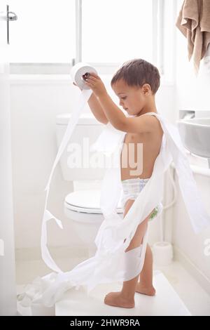 La formation de pot peut être un défi Photo d'un jeune garçon dans les toilettes. Banque D'Images