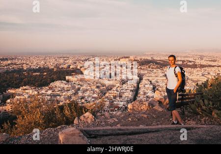 Femme assise sur la colline de Lycabette, le point le plus haut de la ville surplombant Athènes avec l'Acropole - voyageur du monde Banque D'Images