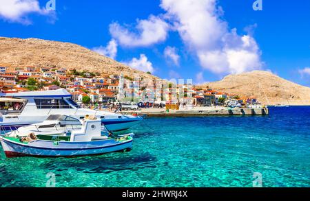 Villages de pêcheurs traditionnels de Grèce - charmante île Chalki (Halki) en Dodécanèse. Vue avec des bateaux typiques et des maisons colorées Banque D'Images