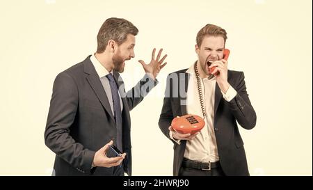 Homme avec un smartphone regarde l'homme d'affaires en colère criant dans le récepteur téléphonique, mauvaise connexion vocale Banque D'Images