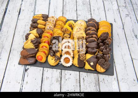 Plateau avec assortiment de gâteaux au chocolat, morceaux d'orange, sucre glace, morceaux d'amande et morceaux de noix Banque D'Images
