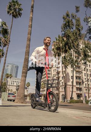 E-scooter en excursion.Bon homme professionnel sur le trottoir.Scooter électrique Banque D'Images