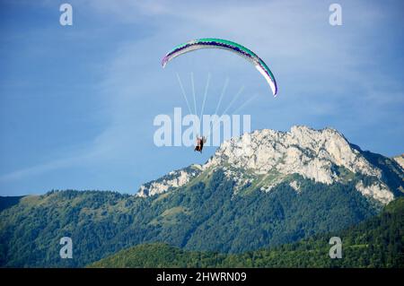 Parapentes volant en tandem et montagnes de Savoie en arrière-plan. Lac d'Annecy, France. Banque D'Images