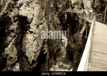 HAUTE-SAVOIE, FRANCE - 23 AOÛT 2015 : les touristes admirent les magnifiques Gorges du fier, canyon de la rivière près du lac d'Annecy. Photo historique sépia Banque D'Images