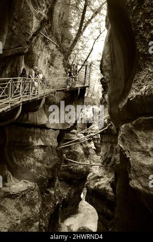 HAUTE-SAVOIE, FRANCE - 23 AOÛT 2015 : les touristes admirent les magnifiques Gorges du fier, canyon de la rivière près du lac d'Annecy. Photo historique sépia Banque D'Images