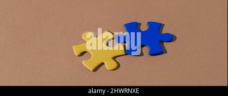 vue en grand angle de deux pièces de puzzle avec les couleurs du drapeau ukrainien sur fond marron, dans un format panoramique à utiliser comme bannière web ou en-tête Banque D'Images